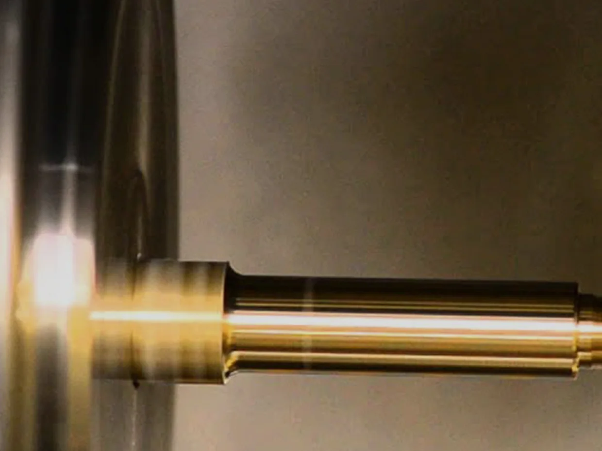 Brass component being turned to size on a lathe