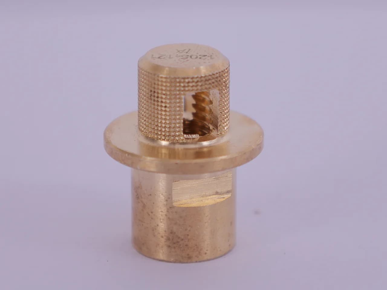 Knurled brass nozzle cap with a windowed sleeve showing the spiral swirl core, stamped with its part number