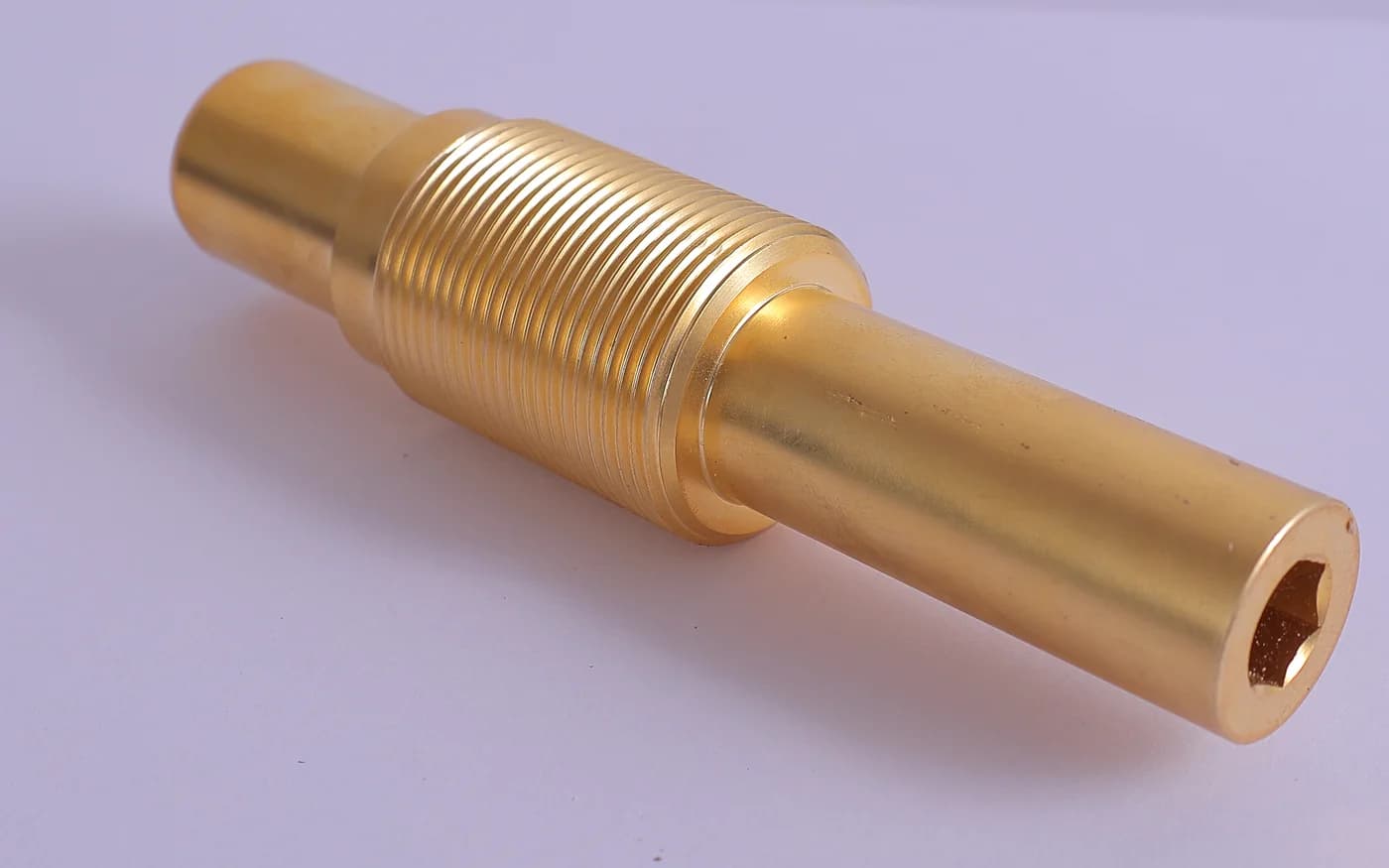 Brass spindle with a fine-pitch thread cut along its length and a hex socket in the end